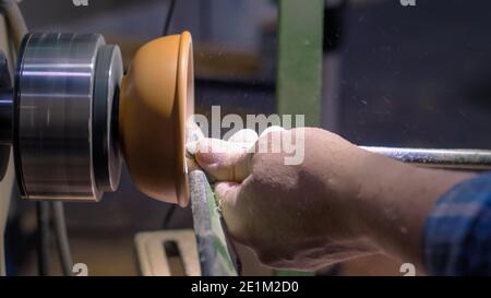 Zimmermann mit Meißel zum Formen von Holzstücken auf der Drehmaschine - Seitenansicht Stockfoto