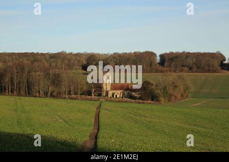 Winteransicht über Felder nach Saint Cosmos und Saint Damian Kirche, Challock, Kent, England Stockfoto