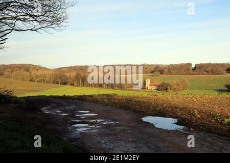 Winteransicht über Felder nach Saint Cosmos und Saint Damian Kirche, Challock, Kent, England Stockfoto