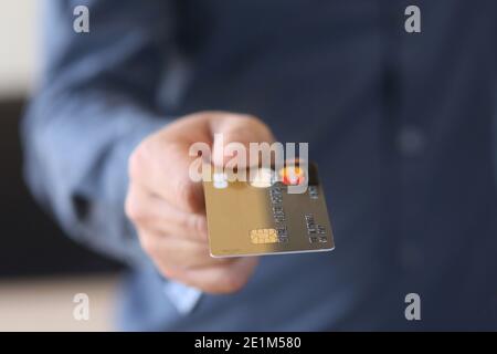 Ein junger Mann hält seine Bankkarte aus - Zahlung Karte Stockfoto