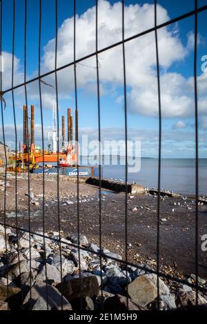 Wave Walker Jack-up Barge hilft beim Bau einer neuen größeren Meeresmauer in Dawlish zum Schutz der Eisenbahn, Devon, England. Stockfoto