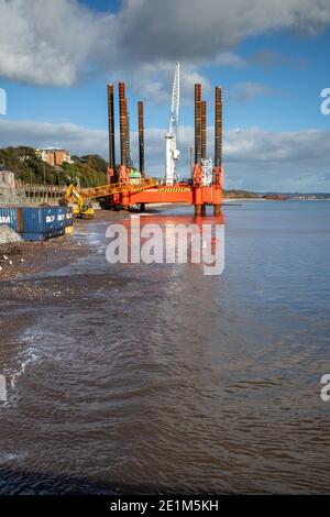 Wave Walker Jack-up Barge hilft beim Bau einer neuen größeren Meeresmauer in Dawlish zum Schutz der Eisenbahn, Devon, England. Stockfoto