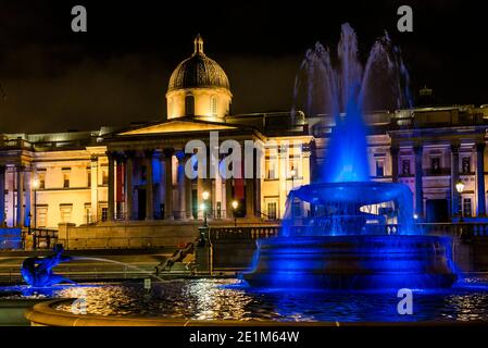 London, Großbritannien. Januar 2021. The Fountains in Trafalgar Sqaure - Londons Skyline ist blau beleuchtet in einer erneuerten Geste des Dankes an den NHS und die Front-Arbeiter, ab Donnerstag, 7. Januar. Wahrzeichen, historische Gebäude und große Sport- und Unterhaltungsorte sind blau beleuchtet - einschließlich London Eye, Trafalgar Square, County Hall und Wembley Arch. Der Bürgermeister von London Sadiq Khan unterstützt die Kampagne. Es ist die erste Woche der nationalen Lockdown 3. Dies ersetzt Tier-4-Beschränkungen und die Regierung Anweisung ist für alle zu Hause zu bleiben, um den Druck auf die NHS zu sparen. Kredit: Guy Bell/Ala Stockfoto