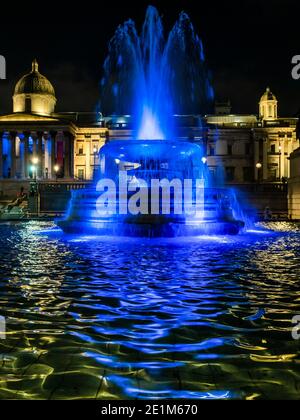 London, Großbritannien. Januar 2021. The Fountains in Trafalgar Sqaure - Londons Skyline ist blau beleuchtet in einer erneuerten Geste des Dankes an den NHS und die Front-Arbeiter, ab Donnerstag, 7. Januar. Wahrzeichen, historische Gebäude und große Sport- und Unterhaltungsorte sind blau beleuchtet - einschließlich London Eye, Trafalgar Square, County Hall und Wembley Arch. Der Bürgermeister von London Sadiq Khan unterstützt die Kampagne. Es ist die erste Woche der nationalen Lockdown 3. Dies ersetzt Tier-4-Beschränkungen und die Regierung Anweisung ist für alle zu Hause zu bleiben, um den Druck auf die NHS zu sparen. Kredit: Guy Bell/Ala Stockfoto