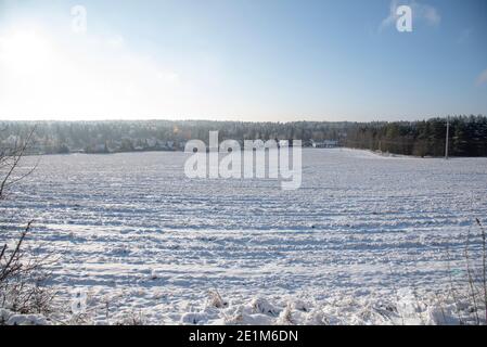 Ein schneebedecktes Dorf am Rande eines weiten Feldes. Stockfoto