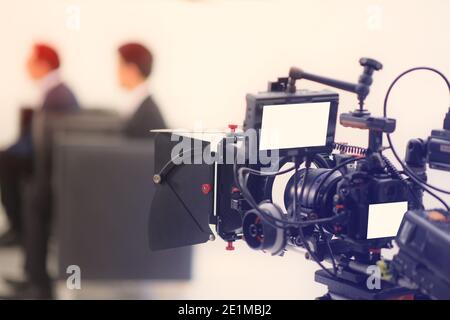Zugeschnittenes Bild eines Videos des Interviews. Fernsehgeräte, Camcorder mit LCD-Bildschirm, Beleuchtungsgeräte. Stockfoto