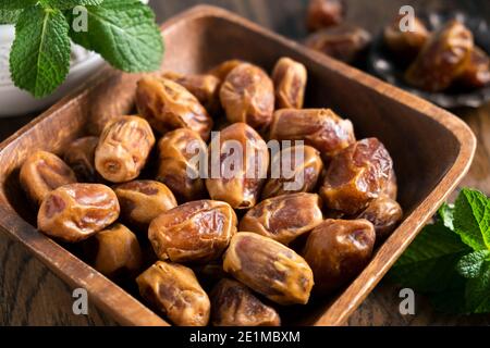 Trockene Palmendaten in einer Holzschale. Gelbe Datteln aus Ägypten, arabisches Essen Stockfoto