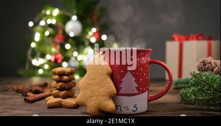Lebkuchen und heiße Schokolade in einer festlichen roten Tasse Vor dem Weihnachtsbaum Stockfoto