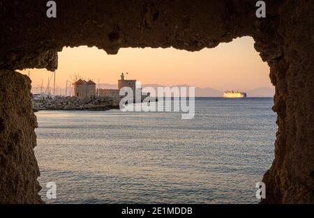 Rhodos Sonnenuntergang über der St. Nicholas Festung und den Windmühlen am Mandraki Hafen, Rhodos Stadt, Rhodos Insel, Griechenland Stockfoto