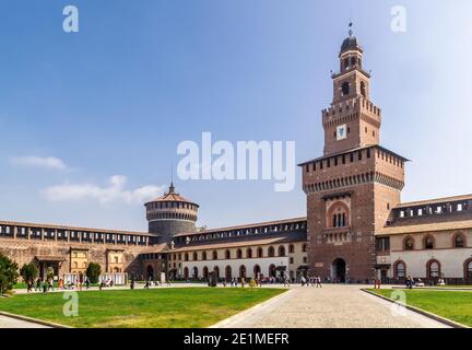 Mailand, Lombardei, Italien - 5. Oktober 2017: Altes mittelalterliches Castello Sforzesco Castello Sforzesco, grüner Rasen des Hofes, blauer Himmel weiße Wolken Hintergrund. Stockfoto