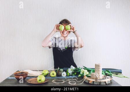 Hobbys und Aktivitäten, Kunst und Kunsthandwerk während Coronavirus. Floristin Frau machen Obst essbare Bouquet. Natürlichkeit, Blumenarrange, Floristen-Tricks Stockfoto