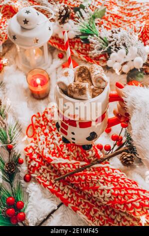 Junge Frau mit einem Schneemannbecher mit Marshmallows Stockfoto