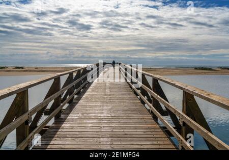 Blick auf Menschen, die über eine lange Holzpromenade nach La gehen Gaviota Strand in Andalusien Stockfoto