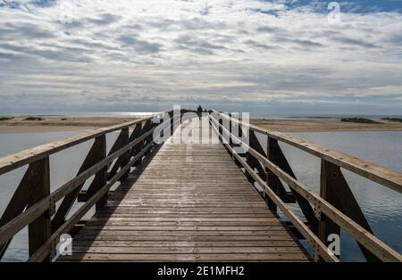 Blick auf Menschen, die über eine lange Holzpromenade nach La gehen Gaviota Strand in Andalusien Stockfoto