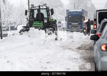 Roetgen, Deutschland. Januar 2021. Ein Traktor räumt bei Roetgen die Straße auf der Bundesstraße B258. Schnee und vereiste Straßen haben in Teilen Nordrhein-Westfalens zu Störungen geführt. Quelle: Federico Gambarini/dpa/Alamy Live News Stockfoto