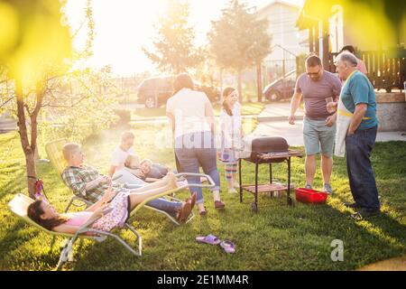 Große glückliche Familie genießen Grillen in ihrem Hinterhof an einem sonnigen Tag. Stockfoto