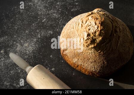 Nahaufnahme des Sauerteigbrots. Frisches Backwarenprodukt auf einem Tisch. Grauer Hintergrund mit Kopierbereich. Köstliches hausgemachtes Vollkornbrot. Stockfoto