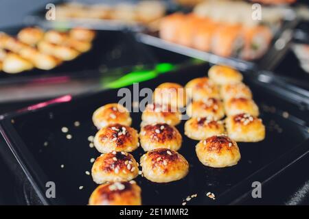 Asiatischer Essenstisch mit verschiedenen Arten von chinesischem Essen, Nudeln, Huhn, Brötchen, Sushi. Serviert auf altem Holztisch, asiatische Essenssuppe, Nudeln und Sushi Stockfoto