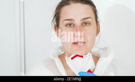 Porträt einer erschöpften Ärztin, die nach dem Kampf gegen Covid-19 und Coronavirus Schutzbrille und Atemschutzmaske auszieht. Stockfoto