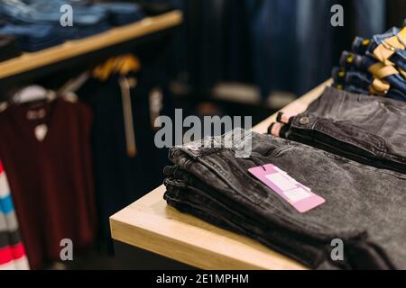 Stapel von blauen und schwarzen Jeans in einem Geschäft. Konzept von Kauf, Verkauf, Shopping und Jeans Mode. Stockfoto