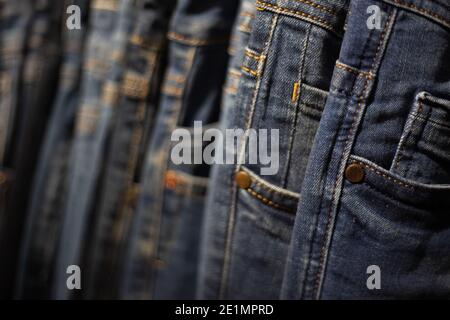 Nahaufnahme viele Jeans hängen an einem Gestell. Reihe von Hosen Denim Jeans hängen im Schrank. Konzept von Kauf, Verkauf, Shopping und Jeans Mode. Stockfoto