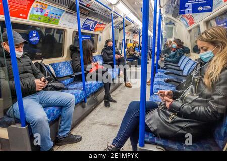 London, Großbritannien. Januar 2021. Die U-Bahn ist immer noch ziemlich voll trotz der neuen nationalen Lockdown, Stay at Home, Anweisungen. Die meisten Reisenden tragen Maskenabdeckungen, die bereits obligatorisch sind. Kredit: Guy Bell/Alamy Live Nachrichten Stockfoto