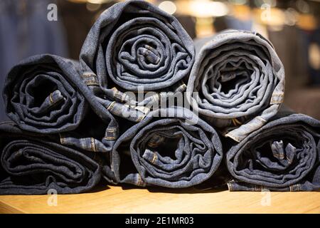 Rollen Sie Jeans aus blauem Denim in einem Geschäft. Jeans-Struktur Nahaufnahme. Stockfoto