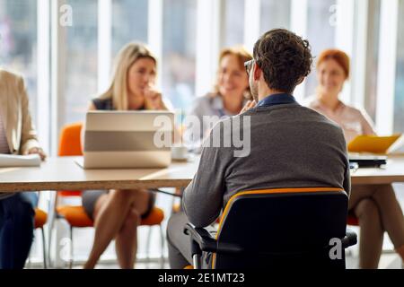 Ein junger männlicher Bewerber, der ein Interview für einen Job bei einer betriebskommission in einer angenehmen Atmosphäre hat. Menschen, Arbeit, Unternehmen, Geschäftskonzept. Stockfoto