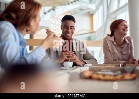 Mitarbeiter, die in einer angenehmen Atmosphäre in der Kantine des Unternehmens eine Pause einlegen. Menschen, Arbeit, Unternehmen, Geschäftskonzept. Stockfoto