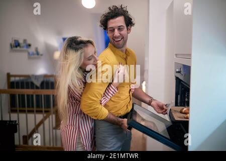 Glückliches Paar Backen zu Hause zusammen in der Küche Stockfoto