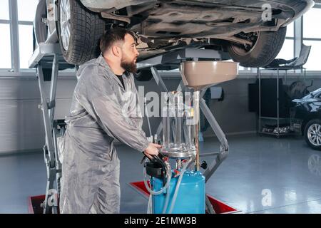 Kfz-Mechaniker Öl im Motor ersetzen. Autoservice Stockfoto