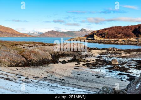 SCHOTTLAND WESTKÜSTE HIGHLANDS KINTAIL SANDAIG FROSTBEDECKTER SANDSTRAND IM SONNENLICHT BEI EBBE UND BLAUEM MEER VON KYLE RHEA Stockfoto