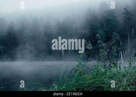 Nebel über der Wasseroberfläche auf dem See. Morgennebel auf dem Fluss Stockfoto