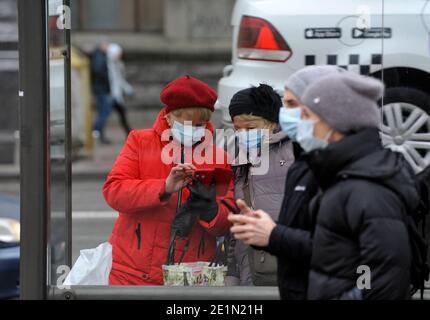 Menschen mit Gesichtsmasken als Vorsichtsmaßnahme gegen die Ausbreitung des Coronavirus gehen während der Coronavirus-Krise auf der Straße.die ukrainische Regierung hat neue Beschränkungen eingeführt, um die Ausbreitung von COVID-19 zu verhindern. Sie sind vom 8. Bis 25. Januar gültig. Für 17 Tage ist die Arbeit von Cafés, Restaurants, Bars, Non-Food-Läden, Non-Food-Märkte, Kinos, Fitness-Clubs, Fitness-Studios, Pools, Theater verboten. Alle Bildungseinrichtungen wurden in den Urlaub geschickt, außer Kindergärten und spezielle Bildungseinrichtungen. Alle öffentlichen Veranstaltungen sind verboten. Stockfoto