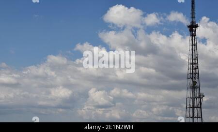 Cloudscape mit industriellen Kommunikations-Tower-Antennen, die Daten übertragen, Repeater für die mobile Kommunikation. 5G Turm mit sich bewegenden weißen Wolken Stockfoto