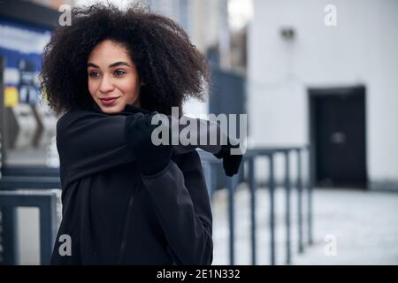 Sportliche Frau, die die rechte Hand in der Stadt streckt Stockfoto