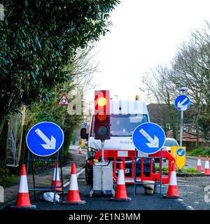 London UK, Januar 08 2021, Red Traffic Lights Anhalten von Fahrzeugen auf der Straße arbeitet mit Richtungszeichen und Kunststoff-Warnkegel und EINE Sicherheitsbarriere Stockfoto