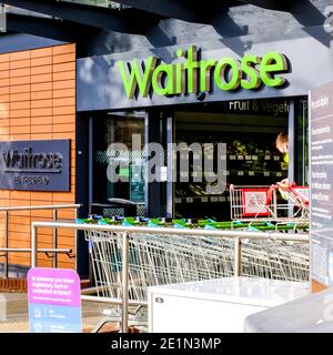 London UK, Januar 08 2021, Offene Eingangstüren zu EINEM John Lewis Waitrose Supermarkt mit Kunden-Shopping Trollys Parked draußen Stockfoto