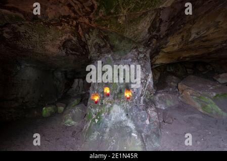 Langenstein, Deutschland. Dezember 2020. Drei rote Kerzen brennen in einer Sandsteinhöhle. Quelle: Stephan Schulz/dpa-Zentralbild/ZB/dpa/Alamy Live News Stockfoto