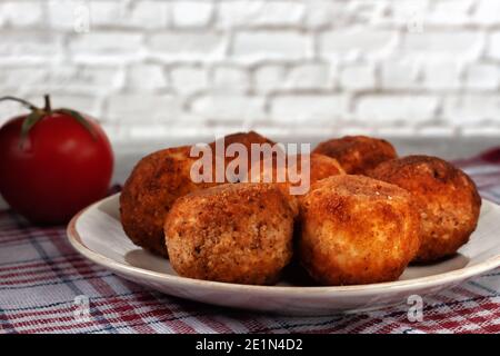 Köstliche heiße italienische arancini - Reisbällchen gefüllt mit Käse In einem Teller auf einem alten Holztisch Stockfoto