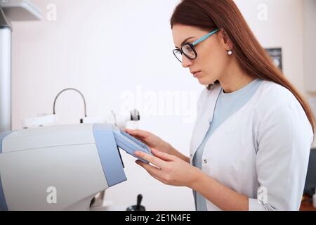 Medizinische Person in Brillen, die die Geräteeinstellungen überprüft Stockfoto