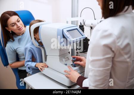 Kind, das auf das Okulare eines automatisierten Refraktors schaut Stockfoto