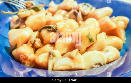 Teller Kartoffel-Gnocchi mit Wurst und Pilzsauce, typisch italienisches Essen Stockfoto