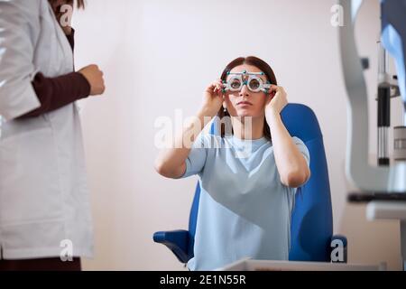 Weibliche Patientin, die eine Testbrille aufsetzt Stockfoto