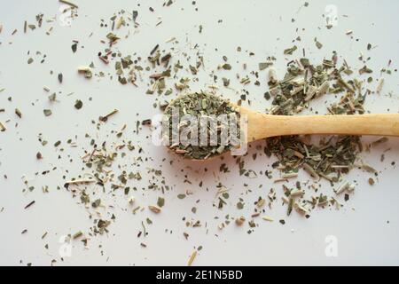 Holzlöffel mit Blättern von Yerba Mate Tee auf weiß Hintergrund Stockfoto