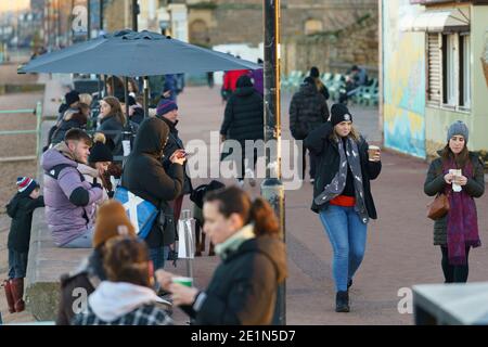 Portobello, Schottland, Großbritannien. Januar 2021. Die Öffentlichkeit zieht am Freitagnachmittag zur Promenade von Portobello, da die Krankenhäuser mit neuen Fällen von Covid-19 auffüllen, und erste Ministerin Nicola Sturgeon erklärt, dass eine noch strengere Sperre in Schottland notwendig sein könnte. Sehr wenig soziale Distanzierung in Evidenz und Cafés bleiben offen für Essen und Getränke zum Mitnehmen. Diese können zum Schließen gezwungen werden, wenn eine schwerere Sperrung erzwungen wird. Iain Masterton/Alamy Live News Stockfoto