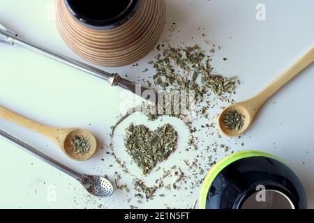 Zusammensetzung auf weißem Hintergrund - Bombilla, Kalabash, Löffel und Blätter von Tee Yerba Mate. Stockfoto