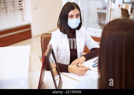 Betroffene medizinische Fachkraft Notizen für ihre weibliche Besucher Stockfoto