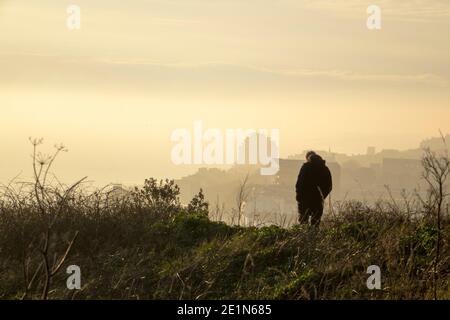 Hastings, East Sussex, Großbritannien. Januar 2021. Ein einziger Wanderer bei nebligen Sonnenuntergang am Castle Hill, Hastings, in Lockdown 3. Carolyn Clarke/Alamy Live News Stockfoto