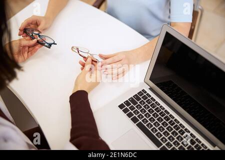 Arzt, der einer Person zwei Brillen vorstellt Stockfoto